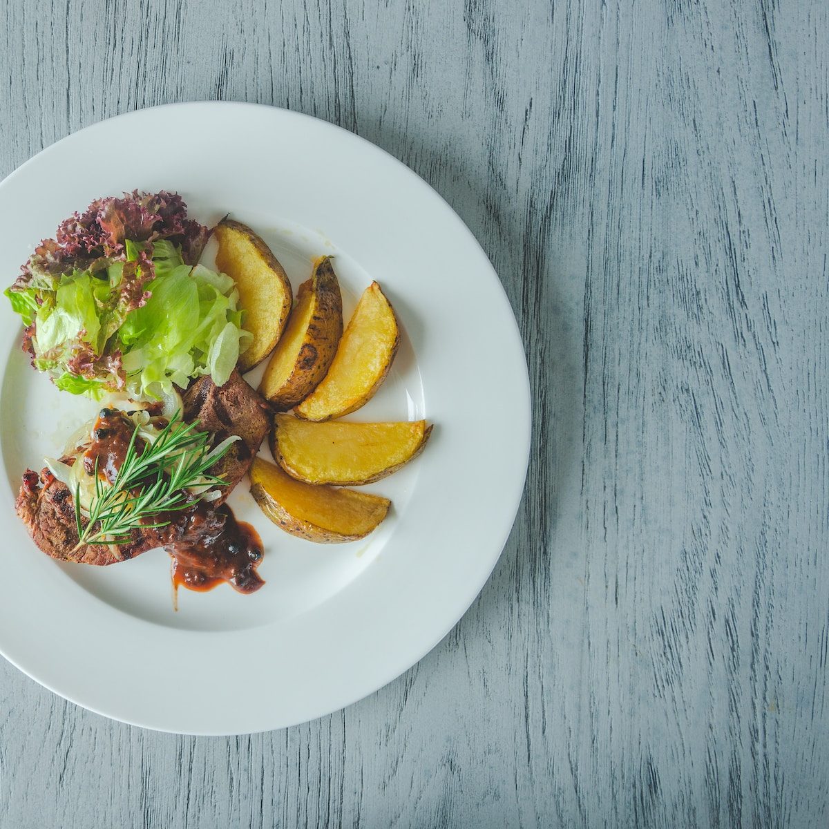 canine cuisine sliced potatoes with meat, and lettuce on plate