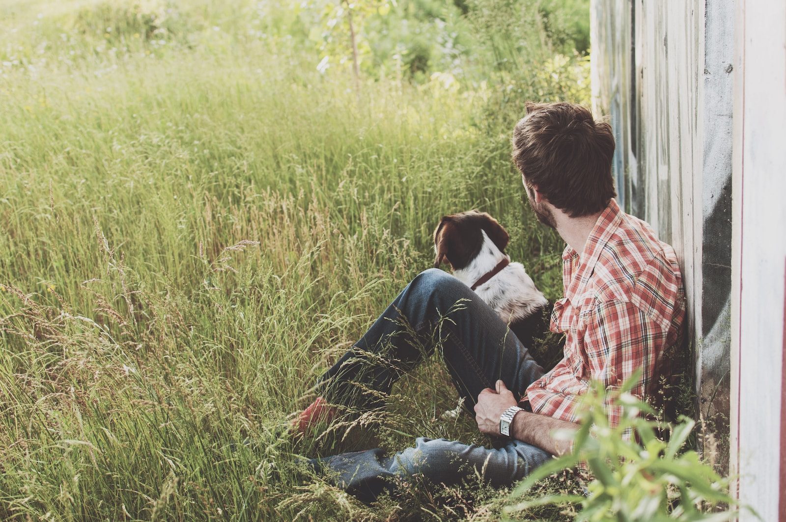 Humane Society Vero Beach man sitting on green grass with white and black dog